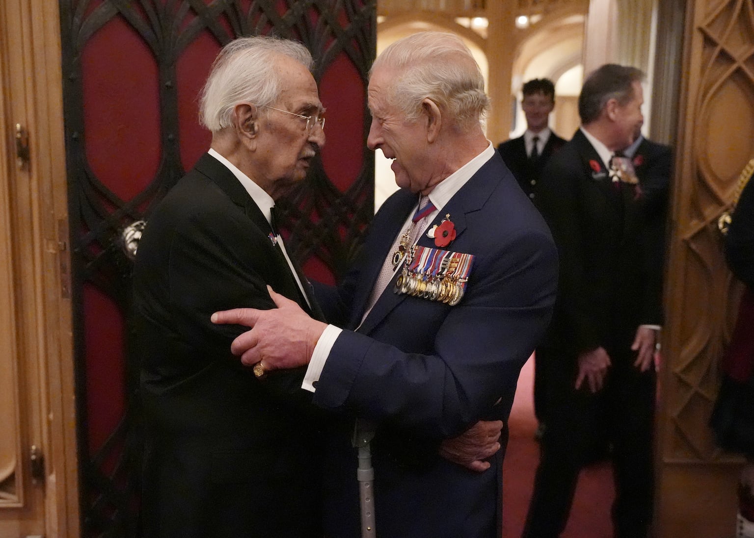 King hugs Second World War veteran, 105, at Windsor remembrance reception